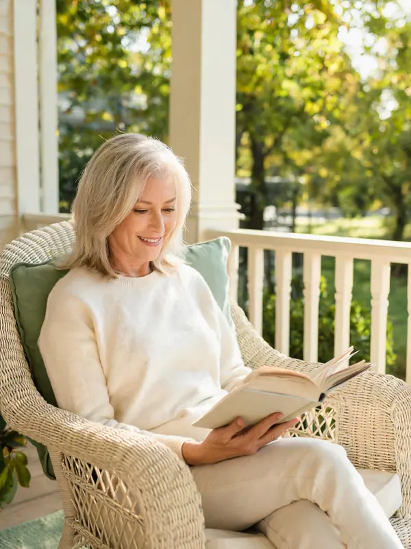 Smiling woman reading a book outdoors